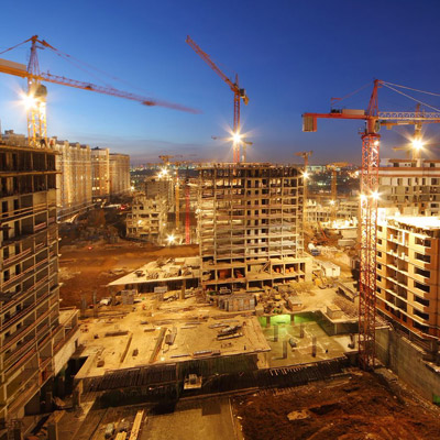 Tower cranes build large residential buildings at night