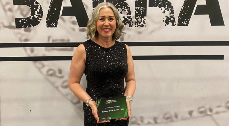 Emma Harbron smiling and holding an award. Link to Teesside University Law Clinic praised for commitment to community.