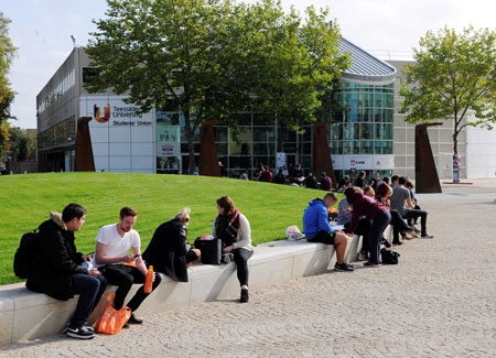 Students sitting in the outdoor green area at Teesside University Students' Union
