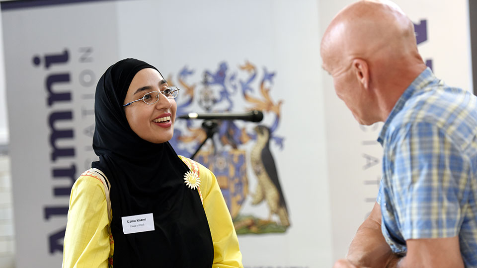 Student and staff member talking at a Teesside University alumni event