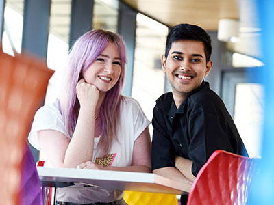 Two students promoting diversity and Teesside University Proud at an LGBTQ+ event.