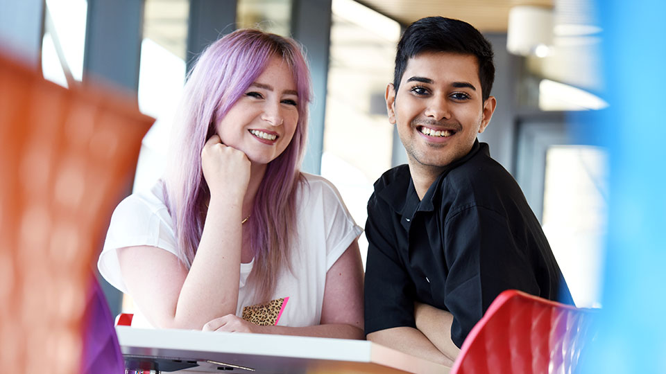 Two students promoting diversity and Teesside University Proud at an LGBTQ+ event.