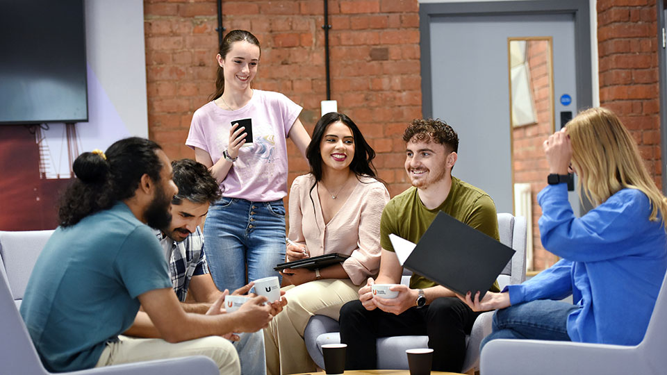 Teesside University students engaged in a supportive conversation, reflecting the collaborative spirit of alumni volunteering