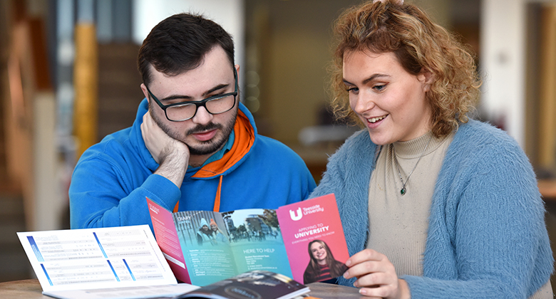 Apply to Teesside University – get guidance from student ambassadors at open days Student and ambassador discussing a leaflet during an open day at Teesside University