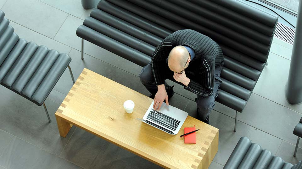 Overhead view of staff member writing on a laptop
