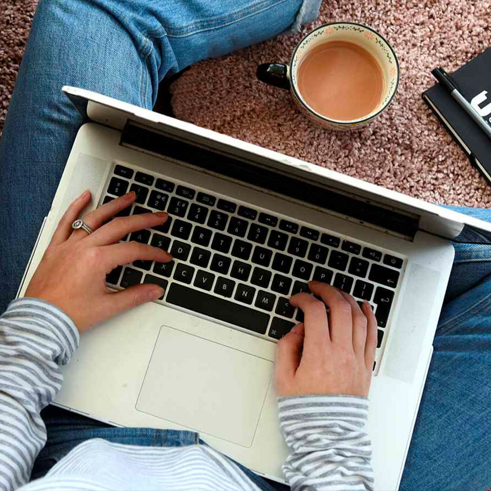 Overhead view of a student writing on a laptop