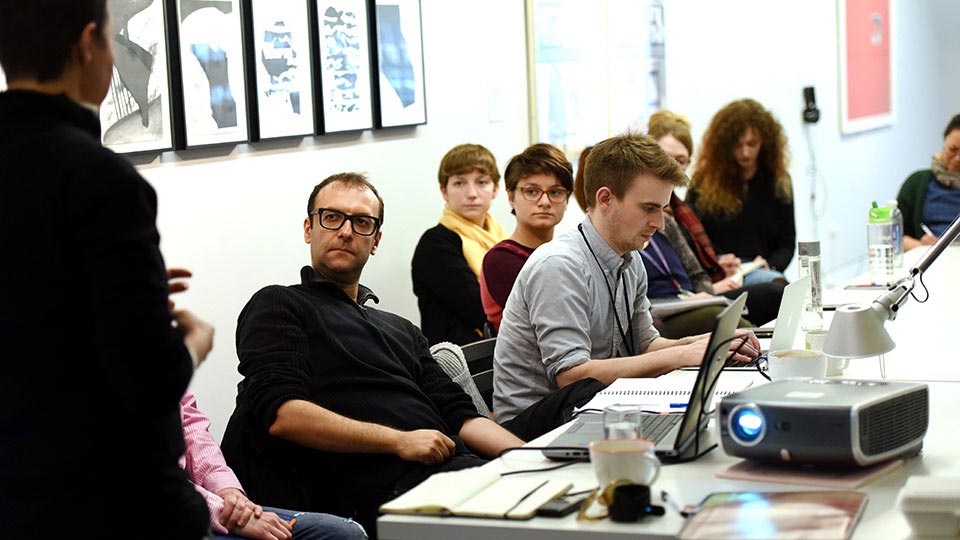 Students and staff seated in a classroom engaged in discussion at Teesside University