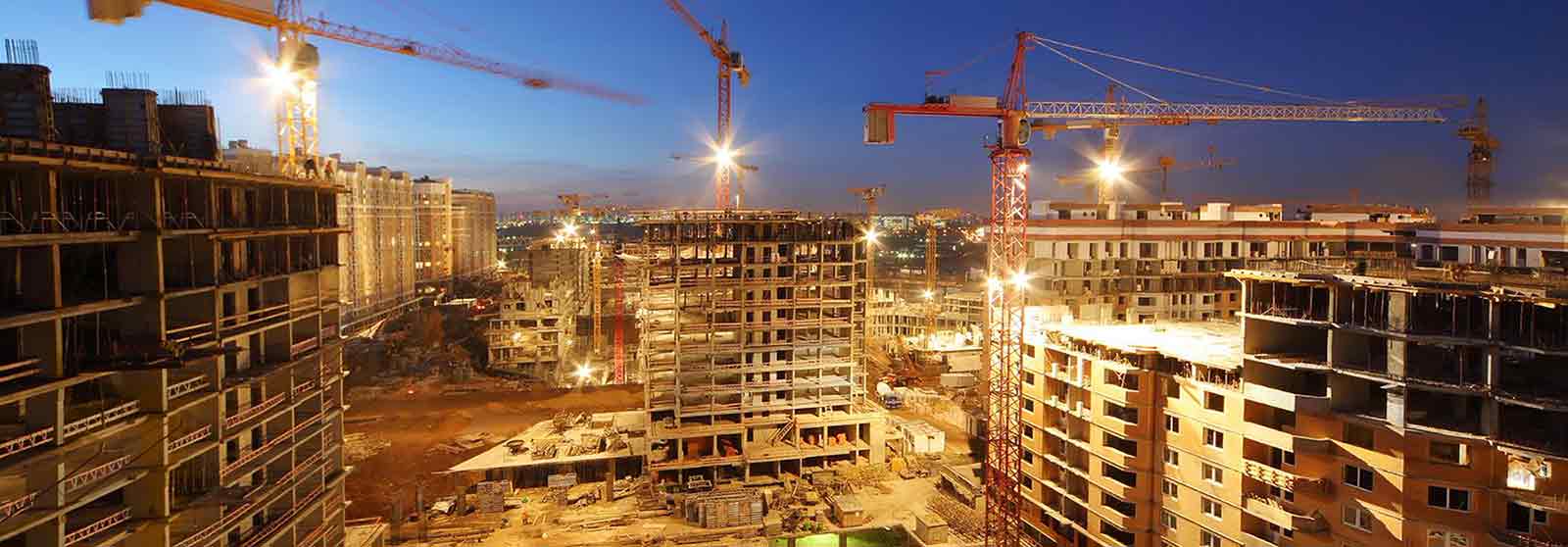 Tower cranes build large residential buildings at night