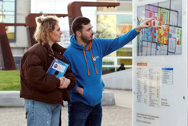 Teesside University ambassador and student looking at a campus map during a tour