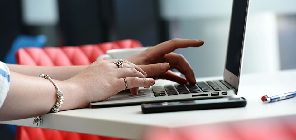 Hands typing on a computer keyboard