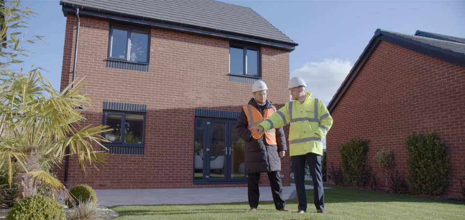 Bellway construction workers standing outside a newly built Bellway house