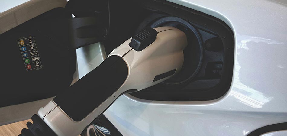 Electric car being plugged in for charging