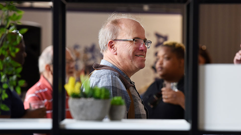 Attendees interacting and networking at a Teesside University alumni event.