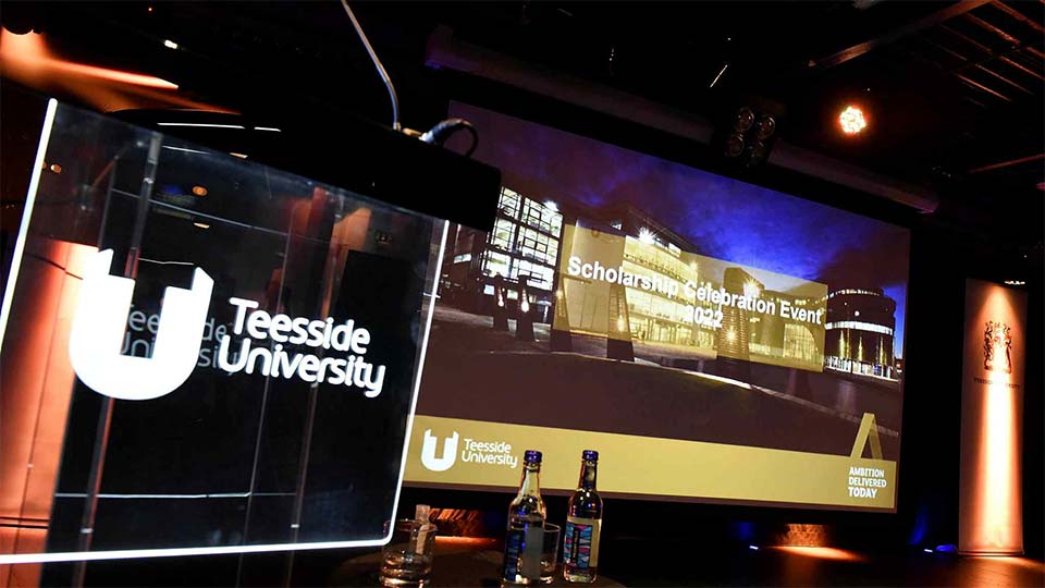 Presentation screen displaying information at a Teesside University scholarship celebration event.