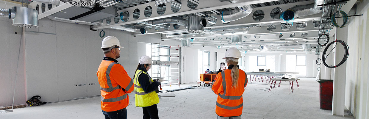 People wearing safety gear working or observing in a construction training room