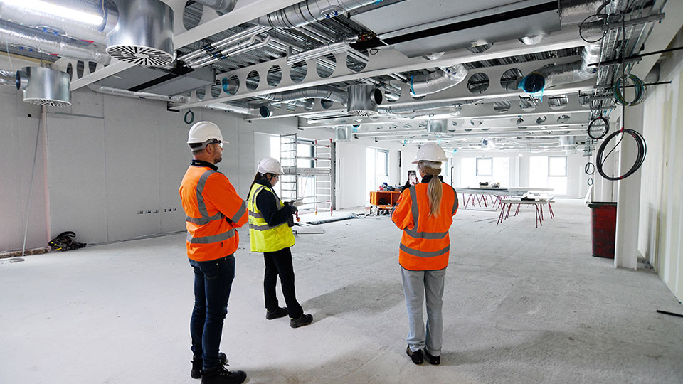 People wearing safety gear working or observing in a construction training room