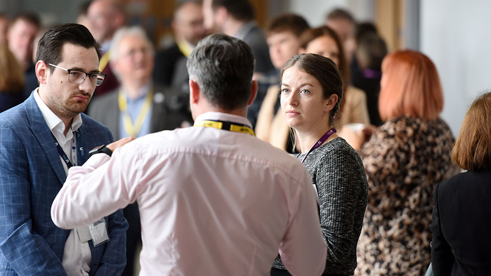 People attending a leadership and management event, engaged in discussion