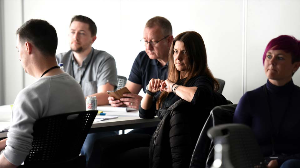  People seated and listening attentively during an indoor event.