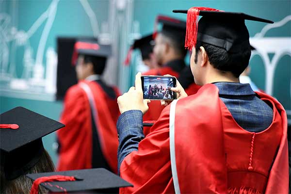 Teesside University London Graduation Graduating students celebrating in caps and gowns at Teesside University London